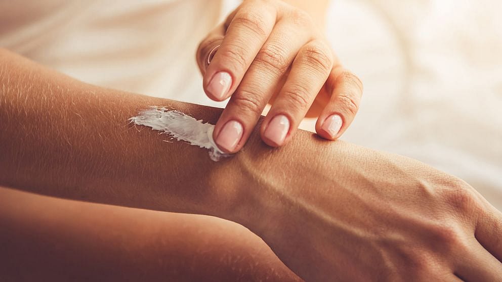 hand applying cream to arm