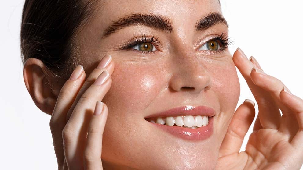 Woman cleansing her face and smiling