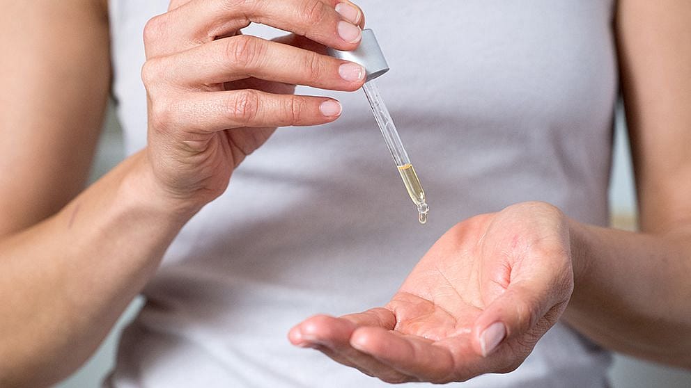 Woman adding serum to her hands