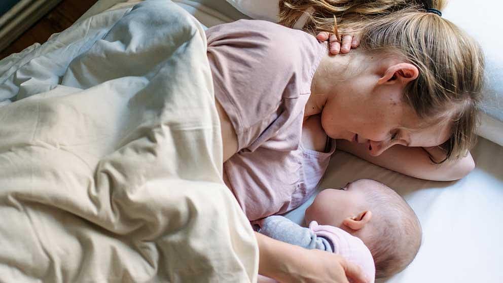 Mother sleeping next to baby.