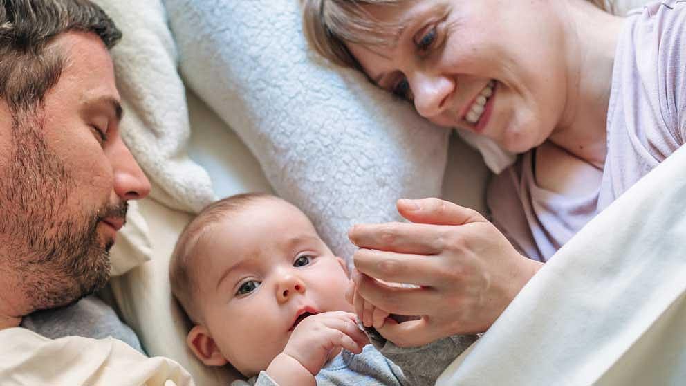 Family in bed with baby in the middle