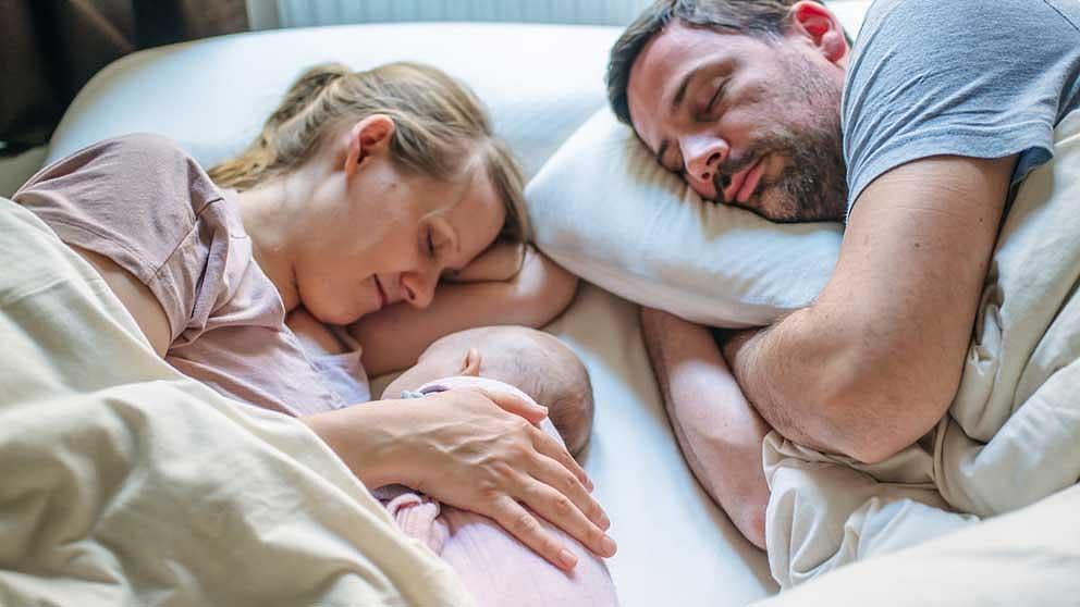 Family sleep in bed.