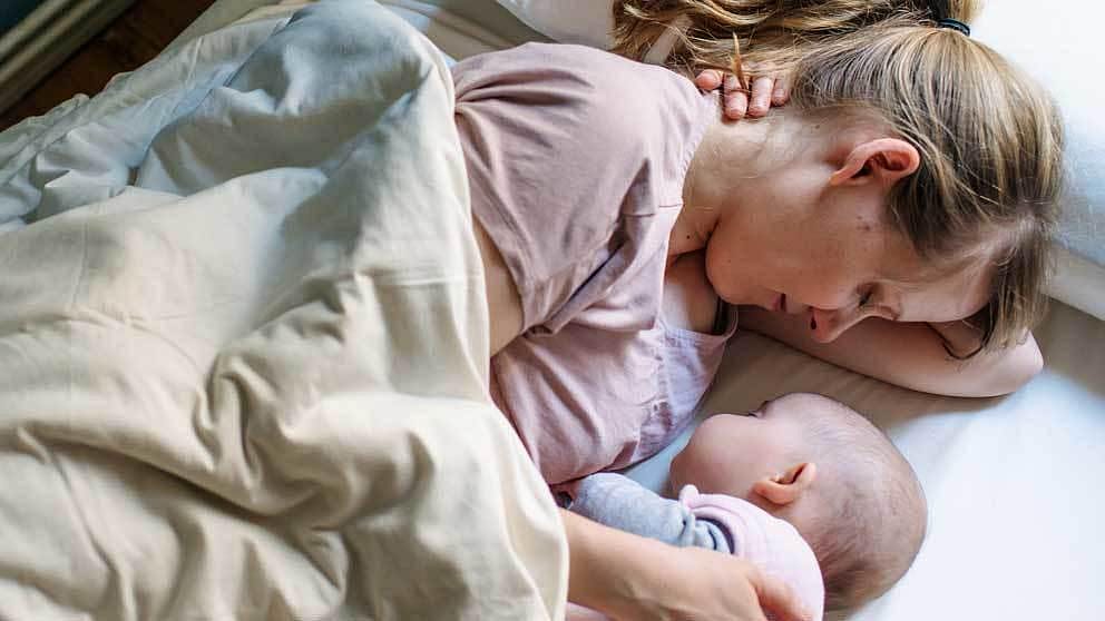 Woman lying in bed with baby.