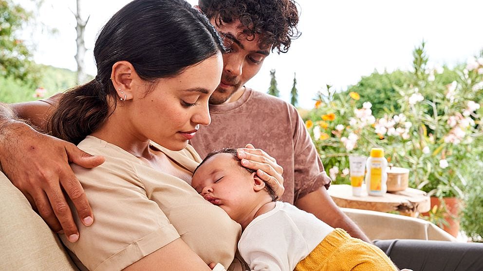 Parents uddling baby on mother