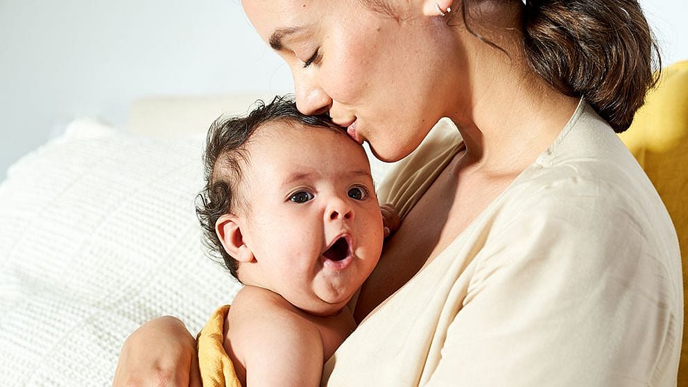 Cooing baby nestled on mum's chest