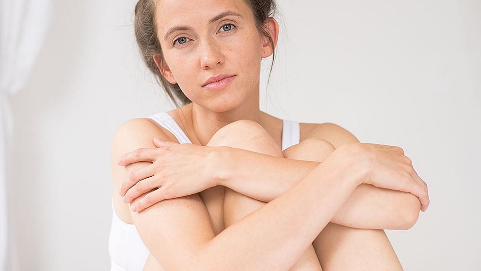 Woman hugging her legs