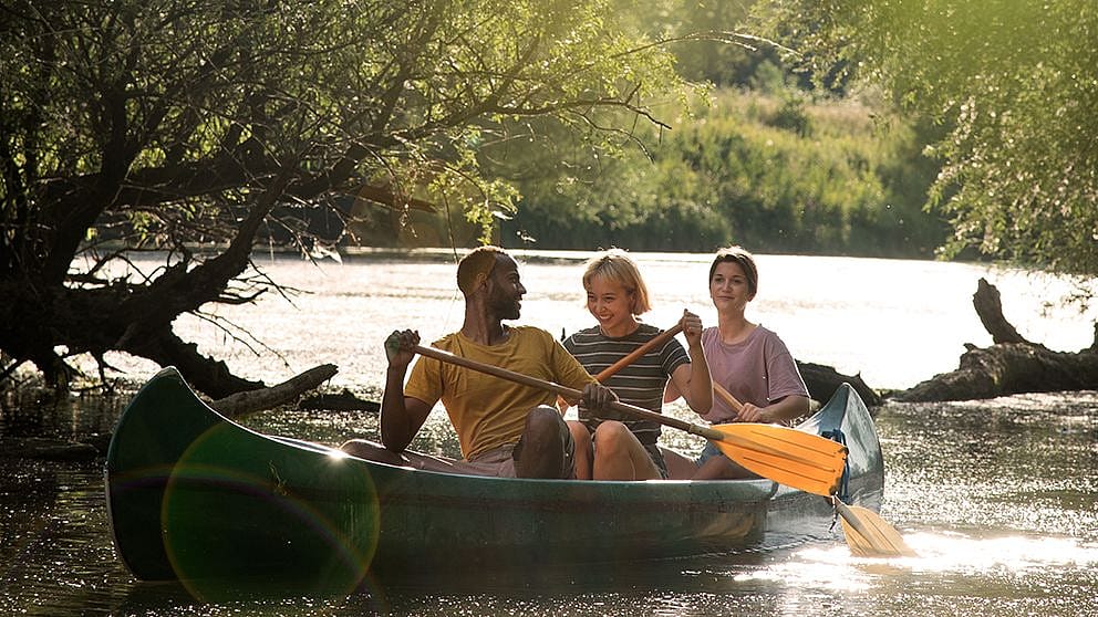 Two women and a man in a canoe.