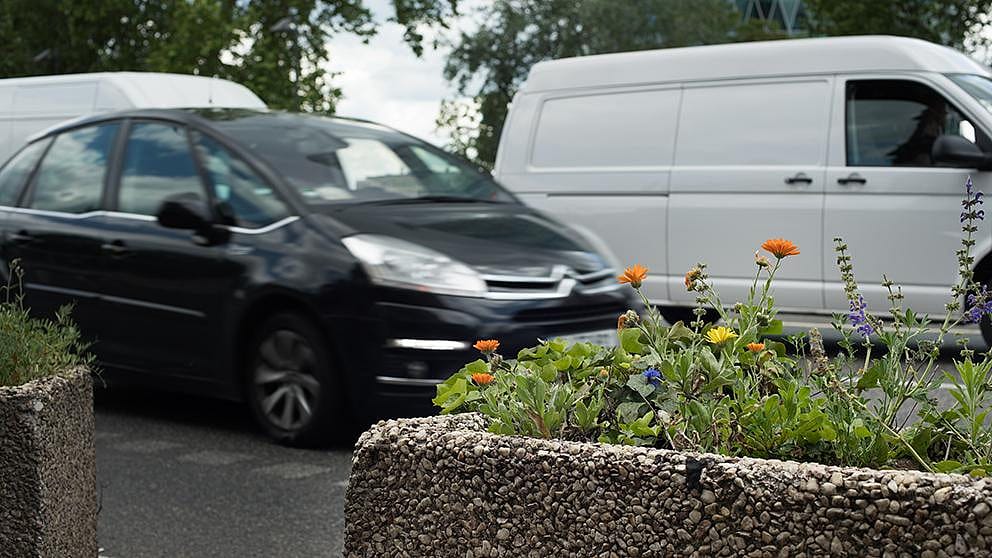 Black car and white van driving past.