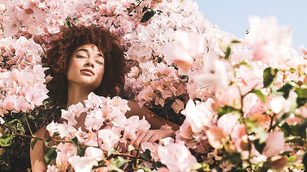 Woman surounded by pink flowers.
