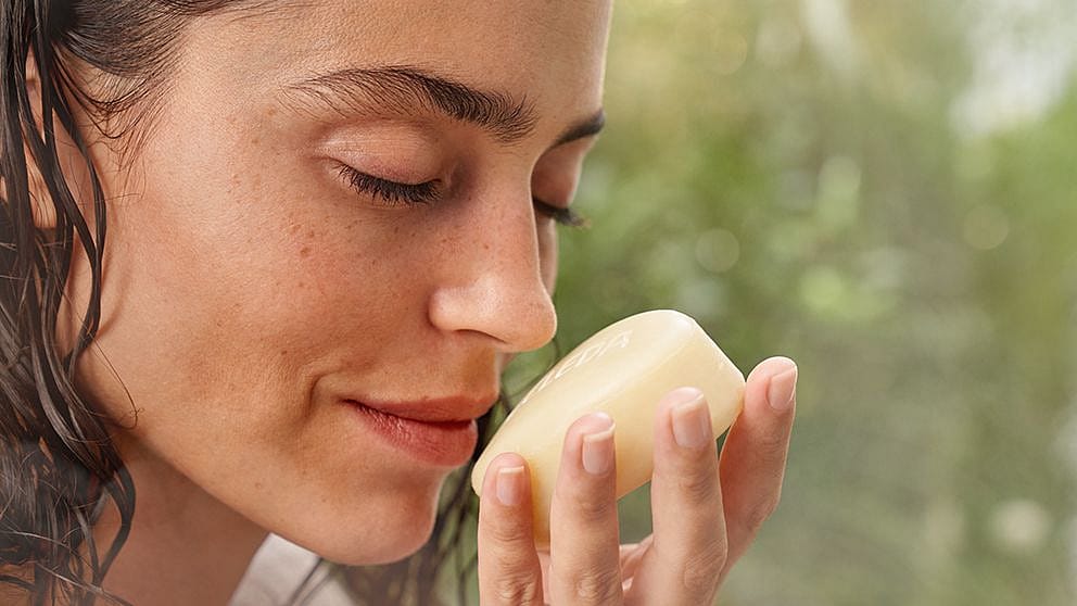 Woman smelling a soap bar.