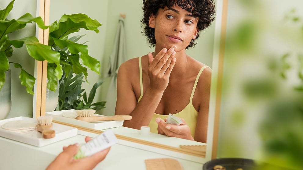 Girl applying Blemished Skin Refining Lotion onot her face