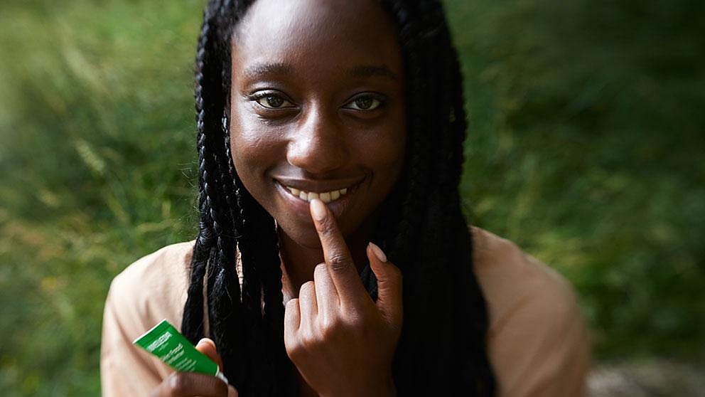 Girl applying Skin Food Lip Balm onot her lips