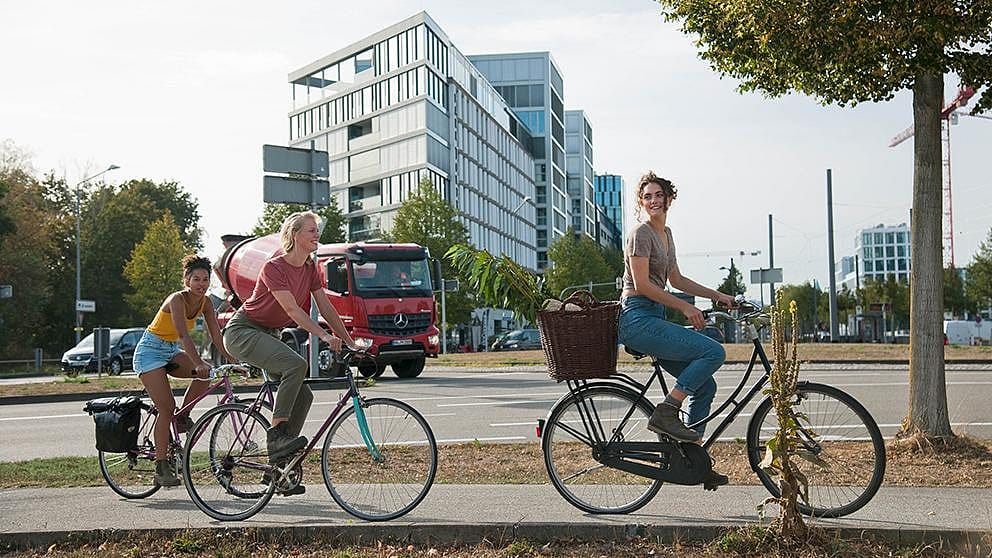 Women riding bicycles through the city.