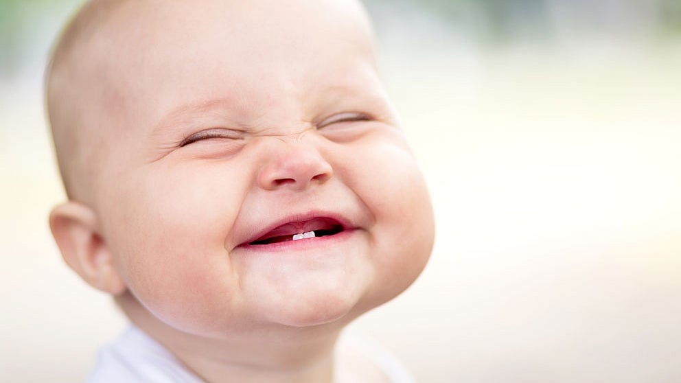 Baby with two bottom teeth grinning