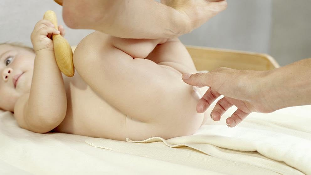 Parent applying nappy cream to baby's bottom