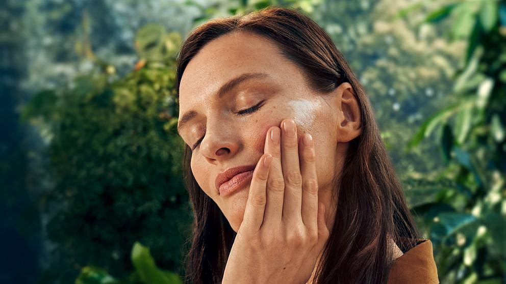 Woman applying cream onto her face